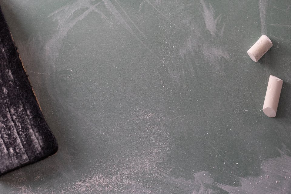 Chalk resting on a blank chalkboard