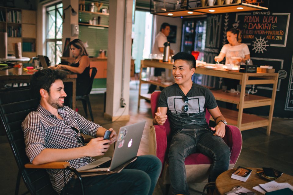 Friends working together on laptops in a café