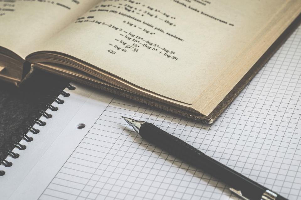 Handwritten maths equations in a notebook
